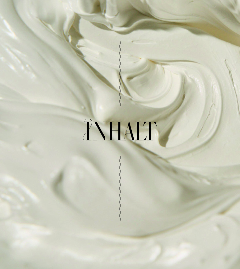Grosse Menge sahniger weisser Creme. "INHALT" Text in der Mitte. Textur sichtbar.